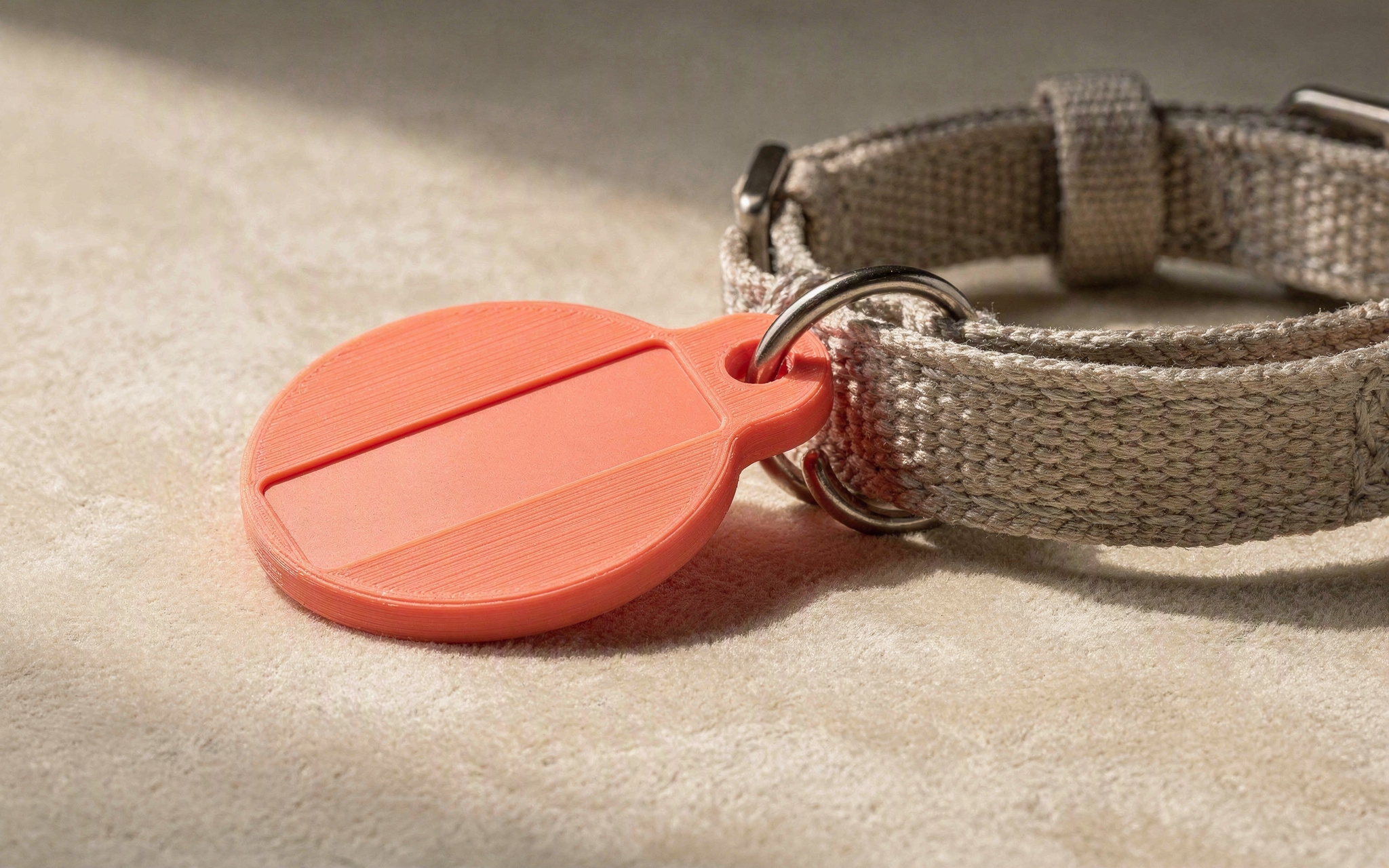 A 3D-printed pet name tag with a blank engraving area beside a collar strap